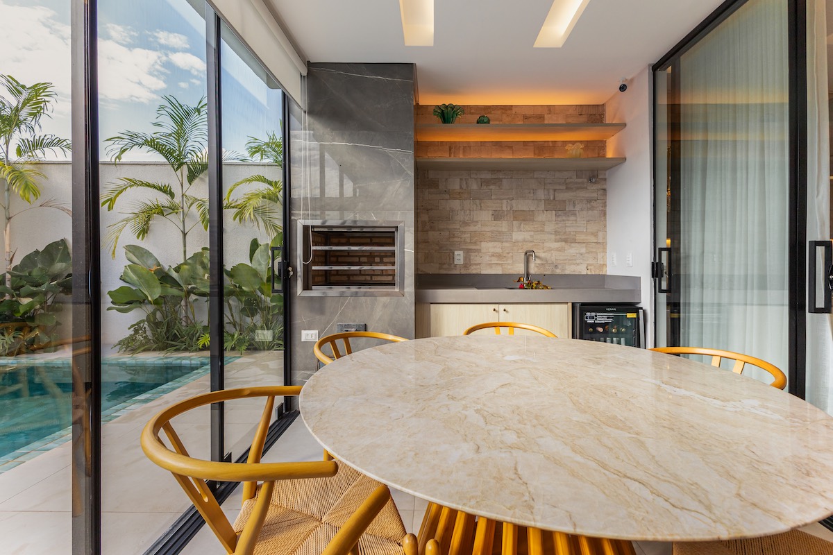 Uma área gourmet que integra interior e exterior, unindo materiais naturais, conforto e convivência.