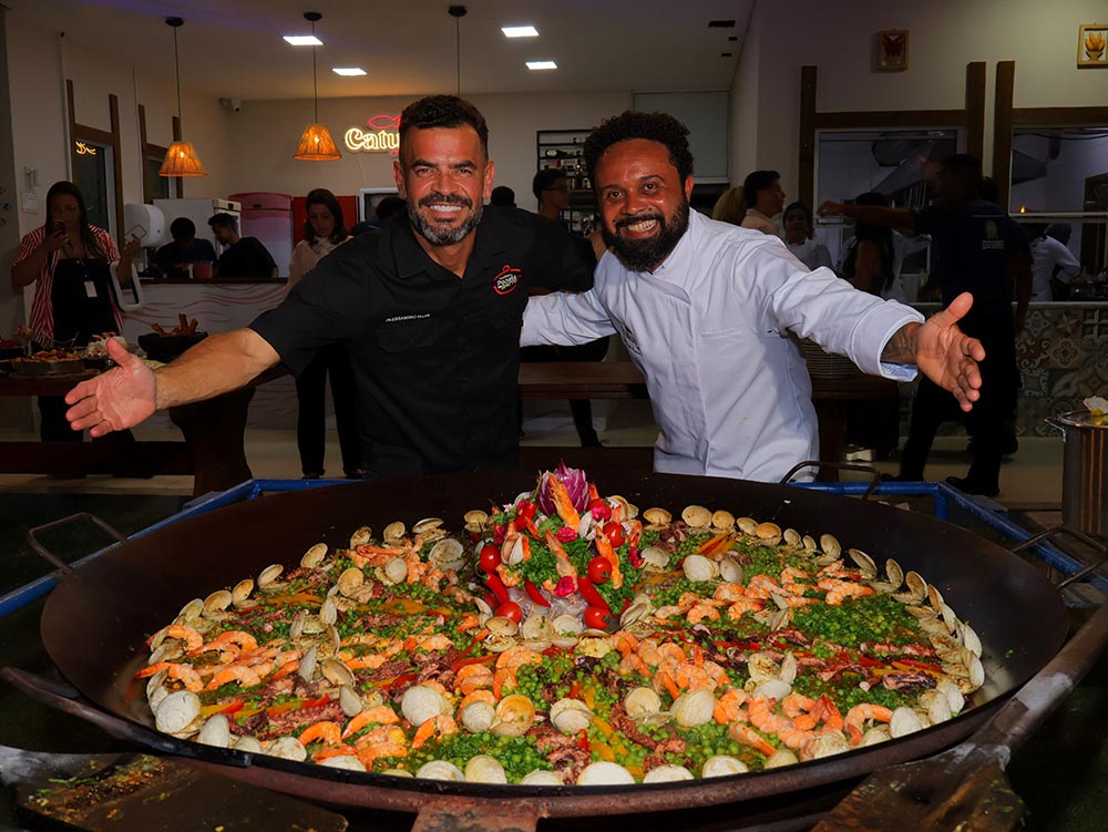 Os chefs Alessandro Eller e David Maresias com a paella gigante preparada ao vivo durante o lançamento do Jacaraípe Gourmet _ crédito  Athilla Hércules